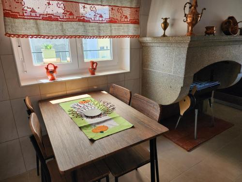 a wooden table with chairs and a fireplace in a room at Casa da Avó Aninhas in Freixo de Espada à Cinta