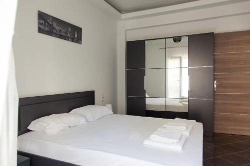 a bedroom with a white bed and a glass shower at Downtown supreme apartment kavala in Kavála