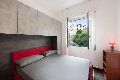 Schlafzimmer mit einem Bett mit einem roten Kopfteil und einem Fenster in der Unterkunft Apartment Aquarium Principe in Genua