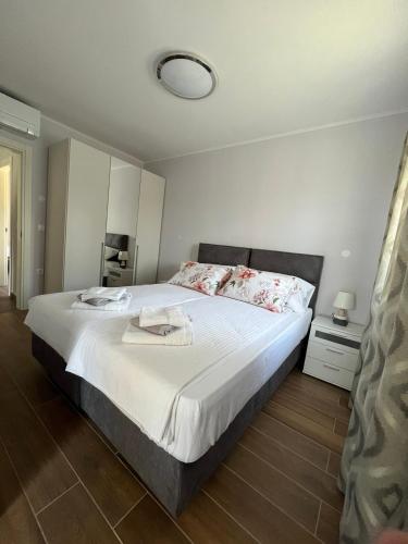 a bedroom with a large bed with white sheets at Apartman David in Rijeka