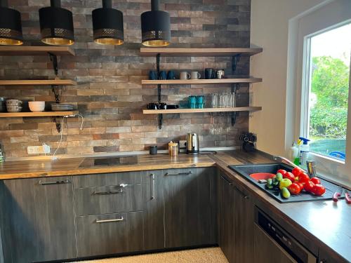 a kitchen with a sink and a brick wall at Una in Bihać