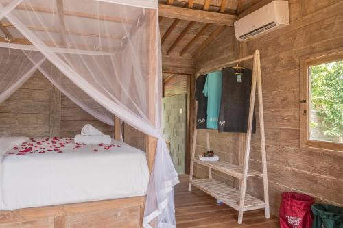 a bedroom with a bed in a wooden room at Nunu Bali Eco Friendly Retreat in Canggu