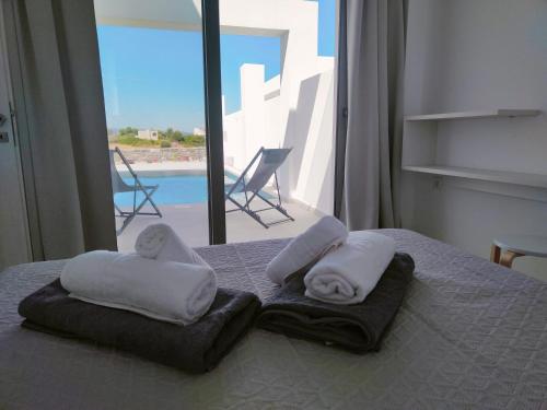 ein Bett mit Handtüchern und Meerblick in der Unterkunft Alpha Villas in Gennadi