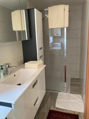 a white bathroom with a shower and a sink at Gartenwohnung Hemma in Eberndorf
