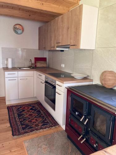 a kitchen with white cabinets and a stove top oven at Gartenwohnung Hemma in Eberndorf