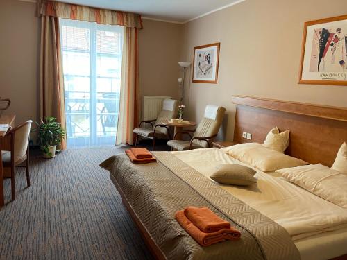 a hotel room with a large bed with an orange towel on it at LD PALACE Spa & Kur in Františkovy Lázně