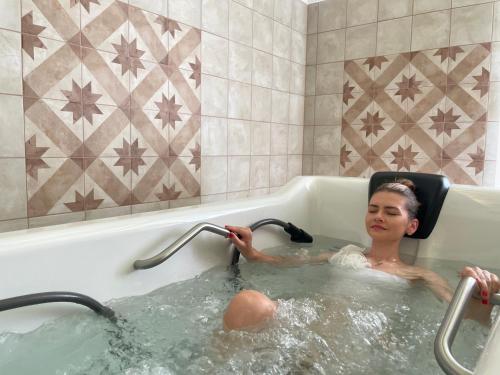 eine Frau in einer Badewanne mit einem Rollstuhl in der Unterkunft LD PALACE Spa & Kur in Franzensbad