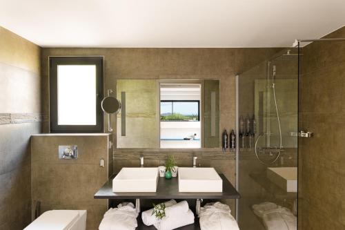 a bathroom with two sinks and a shower at Hôtel Version Maquis Santa Manza in Bonifacio