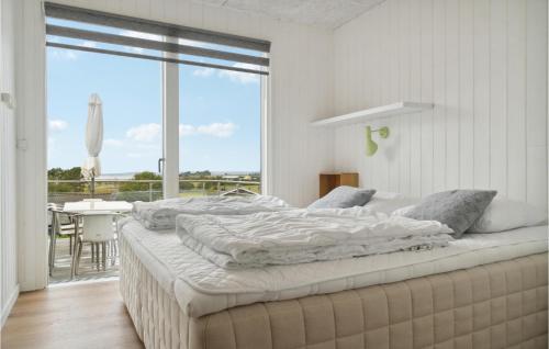 エーベルトフトにあるGorgeous Home In Ebeltoft With Wifiの白いベッドルーム(大型ベッド1台、バルコニー付)