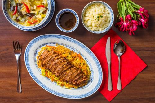 a table with a plate of food with meat and rice at Penzion Panda in Turčianske Teplice