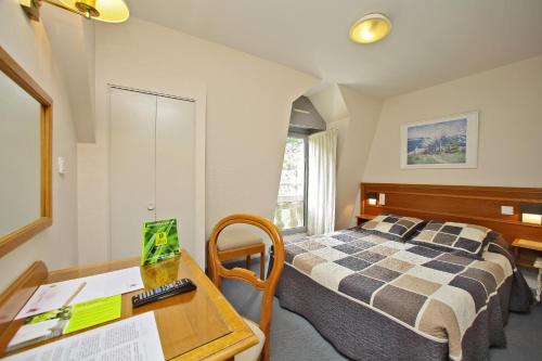 a hotel room with a bed and a desk with a desk at Le Terminus des Pèlerins in Rocamadour