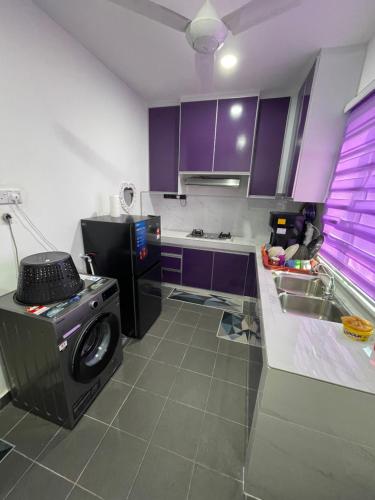 a kitchen with purple cabinets and a washing machine at Homestay Azirah-musleem preferred in Pekan