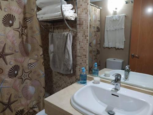 a bathroom with a sink and a mirror at Bajo puerta de Alcazaba in Retamar