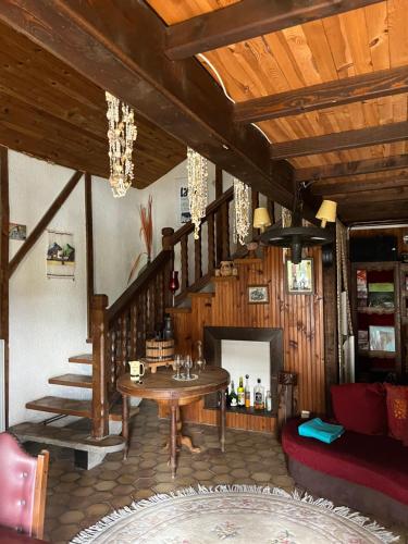 un salon avec une table et un escalier dans l'établissement Maison auvergnate, à Dauzat-sur-Vodable