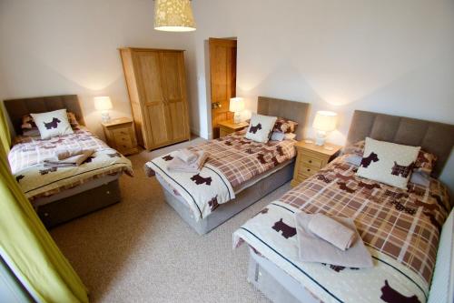 a bedroom with two beds and two night stands at Tigh Muileann in Killin