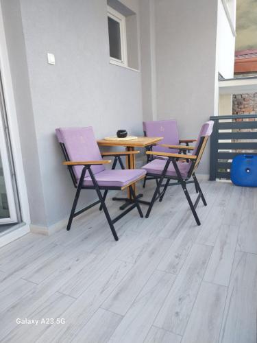 four purple chairs and a table in a room at Apartman Bloom in Osijek