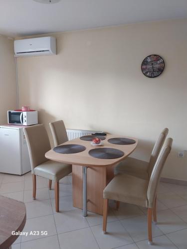 a table and chairs in a room with a kitchen at Apartman Bloom in Osijek