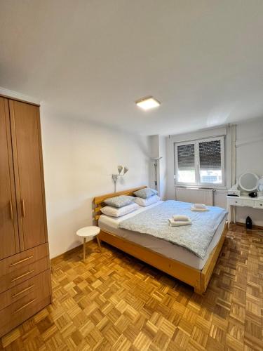 a bedroom with a bed and a wooden floor at ELITE Brcanska Malta in Tuzla