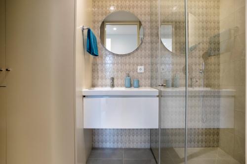 uma casa de banho com um lavatório e uma cabina de duche em vidro. em BONFIM LIVING - Great location, al fresco dining and free private parking no Porto
