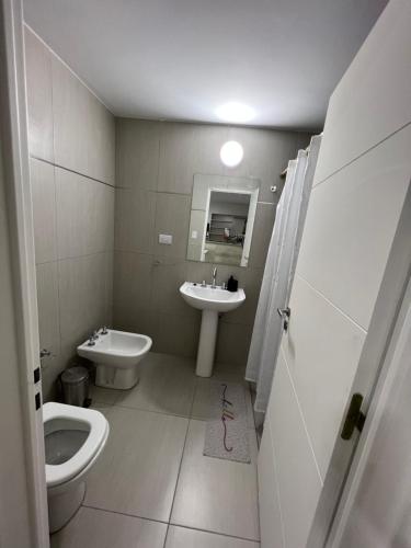 a bathroom with a toilet and a sink at Departamentos y monoambientes Santiago 115 in Neuquén