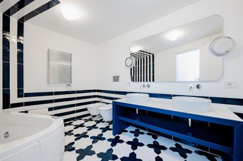 a black and white bathroom with two sinks and a tub at Acquachiara Seaside Luxury Villa in Amalfi Coast in Maiori
