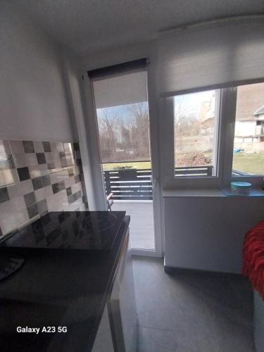 a kitchen with two windows and a counter top at Apartman Bloom in Osijek