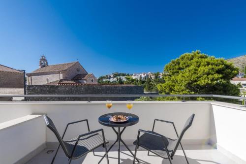 a patio with a table and chairs on a balcony at Apartment & Rooms Primi with FREE PARKING in Dubrovnik