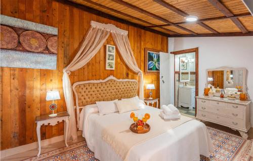 PeñaflorにあるStunning Home In Peaflor With 3 Bedrooms, Wifi And Outdoor Swimming Poolの白いベッド1台が備わる木製の壁のベッドルーム1室