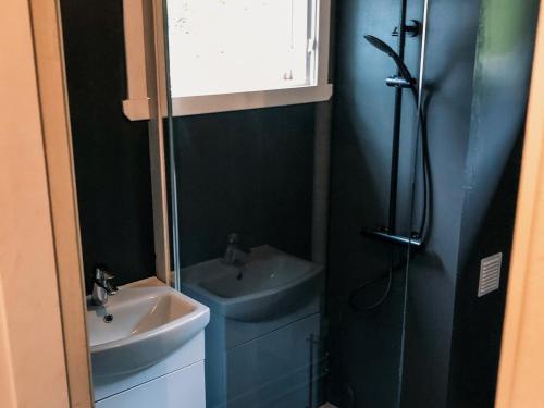 a bathroom with a sink and a shower at Solrik hytte med tilgang til brygge og stor hage in Risør
