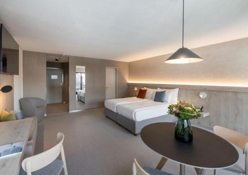 a hotel room with a bed and a table and chairs at Victoria Hotel & Residence in Villars-sur-Ollon