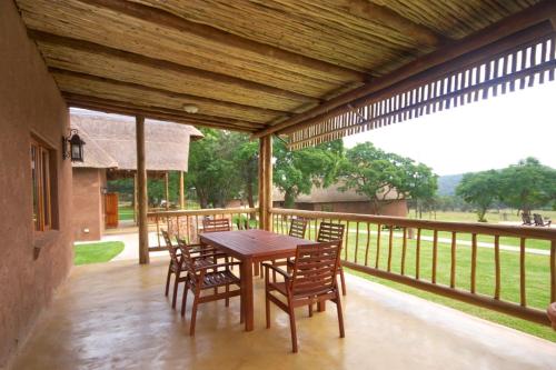 a wooden table and chairs on a porch at Olievenfontein Private Game Reserve in Behoudeniskloof