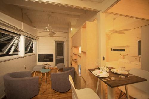 a living room with a table and chairs and a dining room at Between2Waters Chalet rental car offered in Tamarin