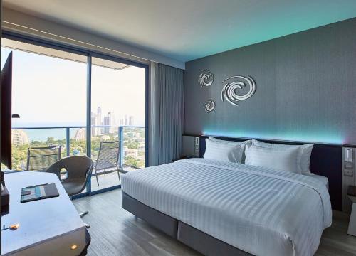 a hotel room with a bed and a balcony at Grande Centre Point Pattaya in Pattaya