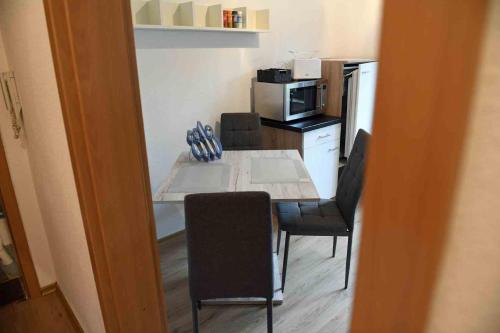 a kitchen with a table with chairs and a microwave at Zum Wohlfühlen in Stadtnähe in Bad Neustadt an der Saale