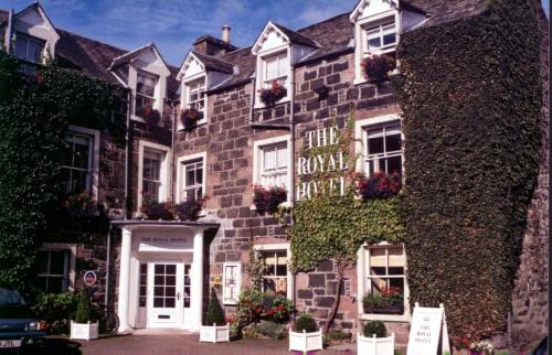 a large brick building with a clock on the front of it at The Royal Hotel in Comrie