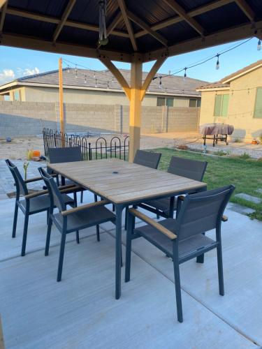 Une table et des chaises en bois sont disponibles sur la terrasse. dans l'établissement Deluxe king Prívate Suite, à Litchfield Park