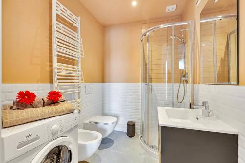 La salle de bains est pourvue de toilettes, d'un lavabo et d'un lave-linge. dans l'établissement Alessia's Flat - Naviglio Grande 2, à Buccinasco