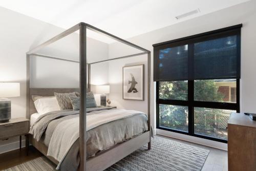 ein Schlafzimmer mit einem Himmelbett und einem großen Fenster in der Unterkunft 145 Biltmore Ave Unit 304 in Asheville