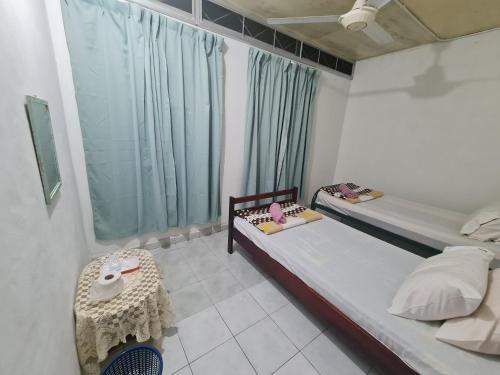 a bedroom with two twin beds and a window at Rainbow Lodge Tambatuon in Kota Belud