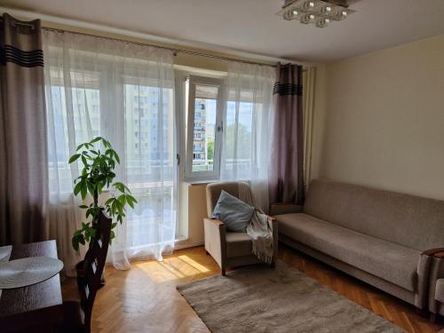 sala de estar con sofá y ventana en APARTAMENT zielona Retkinia - blisko ZOO, Atlas Arena, Mandoria, S14, Lotnisko, en Łódź