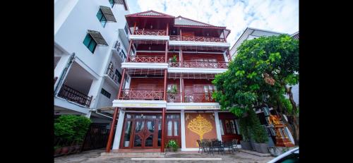 a tall red building with balconies on a street at Phongsavath Boutique Hotel in Vientiane