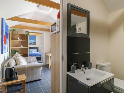 a bathroom with a sink and a living room at Ouzi's Place in Loughborough