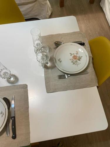 a table with a white plate and a yellow chair at La casa delle Sciure in Ferrere