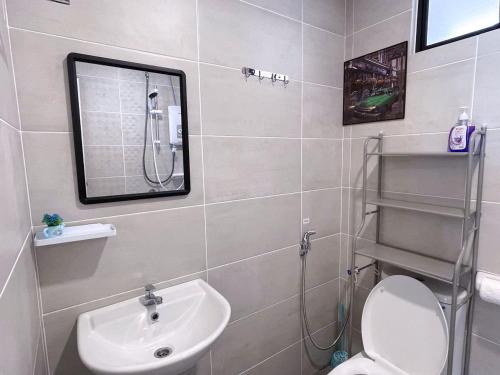 a bathroom with a sink and a toilet and a mirror at Mutiara Melaka Beach Resort by Minso in Tangga Batu
