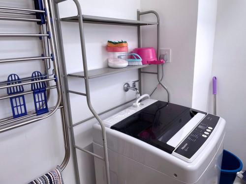 a washing machine in a room with a drying rack at Mutiara Melaka Beach Resort by Minso in Tangga Batu