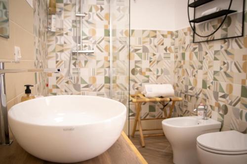 La salle de bains est pourvue d'un lavabo blanc et de toilettes. dans l'établissement La Casetta 2, à Sassari