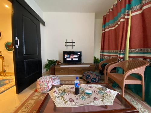 a living room with a table and a tv at porto marina north coast alamein in El Alamein