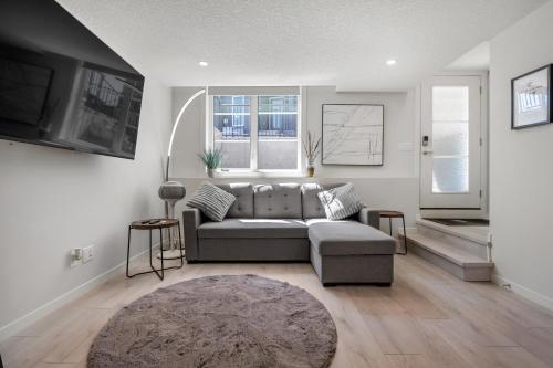 a living room with a couch and a television at Cozy Rockland Park Unit+Parking in Calgary
