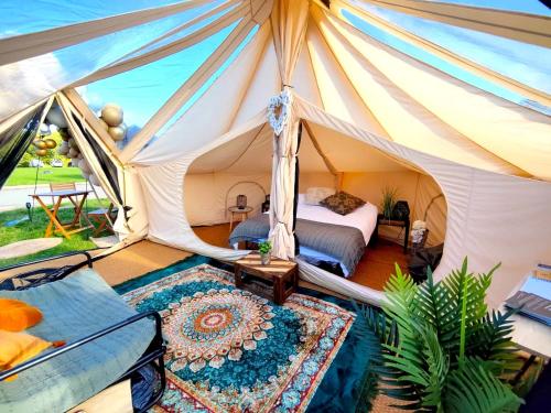 a bedroom in a tent with a bed and a rug at Bell Tent Village in Nottingham