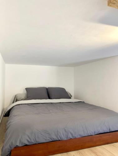 Ce lit se trouve dans une chambre dotée d'un mur blanc. dans l'établissement Hypercentre Gare Cathédrale Hortillonnage, à Amiens